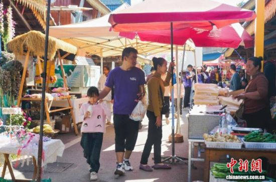 12月7日,跑步爱好者体验磨憨尚岗村的赶摆(当地民族民俗活动)。熊波 摄 12月7日,跑步爱好者体验磨憨尚岗村的赶摆(当地民族民俗活动)。熊波 摄