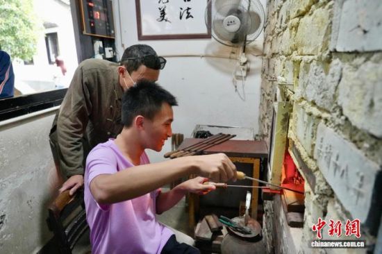 8月23日,台湾青年棋手尝试制作永子。 罗婕 摄 8月23日,台湾青年棋手尝试制作永子。 罗婕 摄