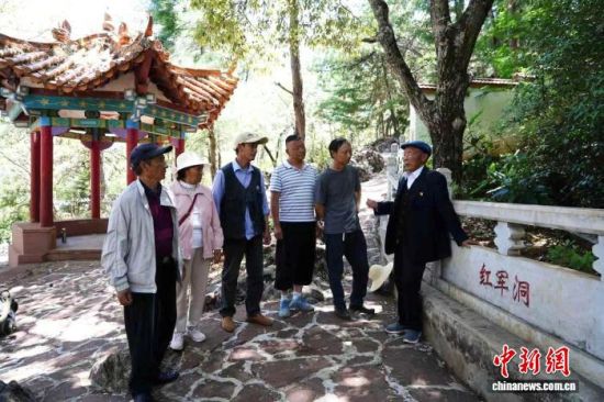 图为白品柱(右)在禄劝县“红军洞”烈士陵园为瞻仰者们讲述红军故事。禄劝县融媒体中心 供图 图为白品柱(右)在禄劝县“红军洞”烈士陵园为瞻仰者们讲述红军故事。禄劝县融媒体中心 供图