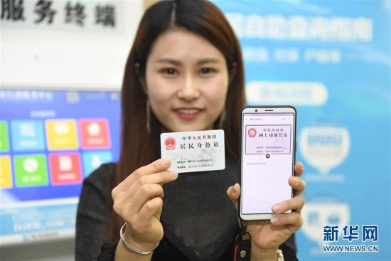 4月17日,在浙江省衢州市行政服务中心,市民蒋女士展示在支付宝手机客户端上领取的“居民身份证网上功能凭证”。新华社记者 黄宗治 摄