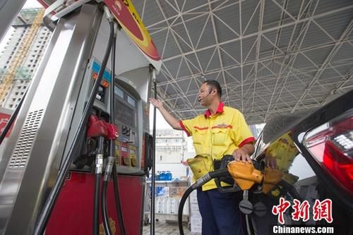 资料图为山西太原一加油站,工作人员正在加油。中新社记者 张云 摄