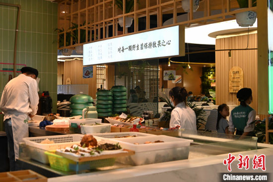 图为7月11日,云南昆明,一家野生菌火锅店内的工作人员在开放式厨房内处理野生菌。 中新社记者 李嘉娴 摄