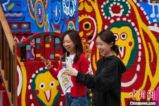5月30日,市民手拿刚买的美食自拍。中新社记者 刘冉阳 摄